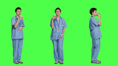 Healthcare-specialist-enjoying-hot-coffee-cup-against-greenscreen-backdrop